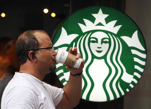 In this July 11, 2013  file photo, a man drinks a Starbucks coffee in New York. Starbucks reports quarterly financial results on Thursday, July 24, 2014. (AP Photo/Mark Lennihan, File)