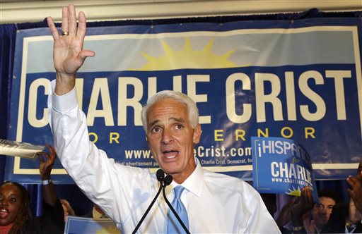 Former Republican Gov. Charlie Crist waves to supporters while speaking at a victory party after Florida's primary election, Tuesday, Aug. 26, 2014 in Fort Lauderdale, Fla. Crist defeated Nan Rich, a former Senate Democratic leader who has been campaigning for governor longer than Crist has been a Democrat. He is the first person in Florida to win the nomination for governor as a Republican and a Democrat. At right is Crist's wife Carole. (AP Photo/Wilfredo Lee)