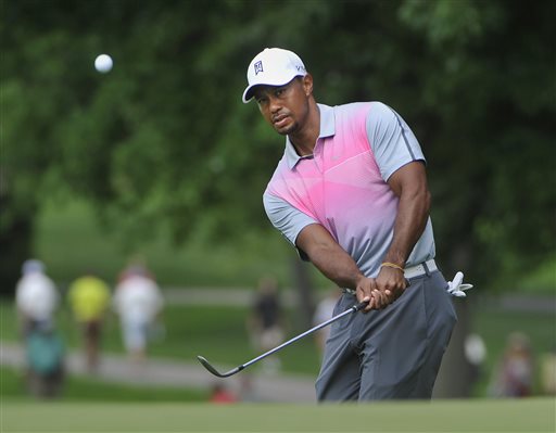 Tiger Woods watches his chip to the fourth hole, during the first round of the Bridgestone Invitational golf tournament, Thursday, July 31, 2014, in Akron, Ohio. (AP Photo/Phil Long)