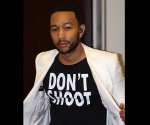 This Aug. 20, 2014 photo released by singer John Legend shows Legend wearing a T-Shirt that says "Don't Shoot," in reference to the Aug. 9 shooting of Michael Brown in Ferguson, Mo., at the Hollywood Bowl in Los Angeles. Legend performed Marvin Gayes Whats Going on with the Los Angeles Philharmonic. (AP Photo/Ron Stephens II)