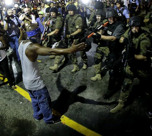 Police arrest a man as they disperse a protest in Ferguson, Mo., early Wednesday, Aug. 20, 2014. On Saturday, Aug. 9, a white police officer fatally shot unarmed 18-year-old Michael Brown, who was black, in the St. Louis suburb. (AP Photo/Charlie Riedel)