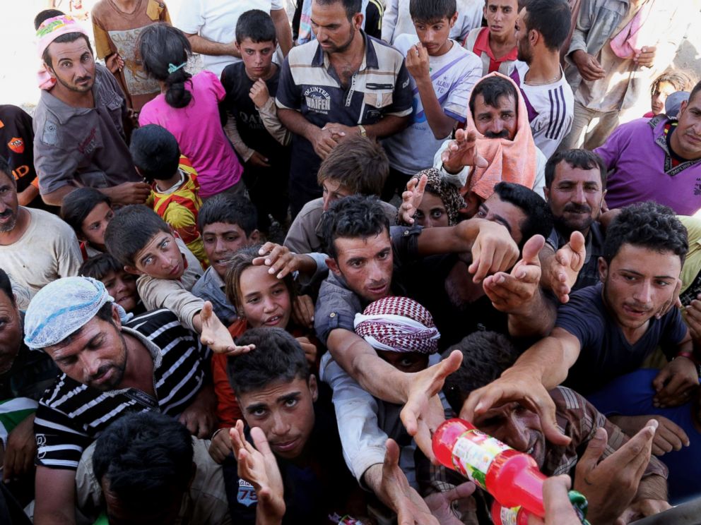 Displaced Iraqis from the Yazidi community gather for humanitarian aid at the Iraq. (Khalid Mohammed/AP)