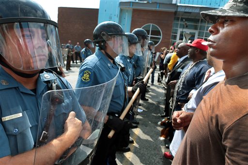 Protestor Boss Bastain of St. Louis locks arms with others as they confront Missouri State Highway Patrol troopers in front of the Ferguson police station on Monday, Aug. 11, 2014.  Marchers are entering a third day of protests against Sunday's police shooting of Michael Brown. (AP Photo/St. Louis Post-Dispatch, Robert Cohen)