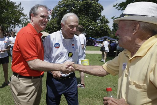 In this file photo taken June 14, 2014, Democratic U.S. Sen. Mark Pryor, left, campaigns for re-election with his father, former U.S. Sen. David Pryor, D-Ark., center, in Warren, Ark. Mark Pryor is reaching into his own medical history to explain his vote on the nations new health care law, telling Arkansans that his battle with a rare cancer 18 years ago influenced his vote. (AP Photo/Danny Johnston, File)