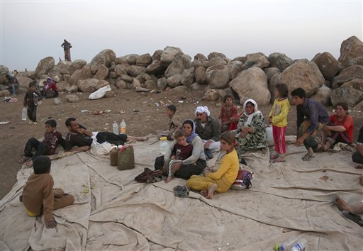 Displaced Iraqis from the Yazidi community settle at a camp in Derike, Syria, Sunday, Aug. 10, 2014. Kurdish authorities at the border believe some 45,000 Yazidis passed the river crossing in the past week and  thousands more are still stranded in the mountains. (AP Photo/ Khalid Mohammed)