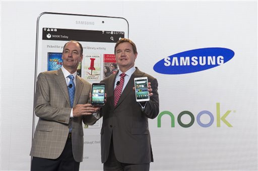 Tim Baxter, president of Samsung Electronics America, left, and Mike Huseby, CEO of Barnes & Noble, pose for a photograph during the unveiling of the Samsung Galaxy Tab 4 Nook, a co-branded tablet that will replace B&N's Nook, Wednesday, Aug. 20, 2014, in New York. The 7-inch tablet will sell for $179 after a $20 instant rebate, the same entry price of the non-branded Samsung Galaxy Tab 4. (AP Photo/John Minchillo)