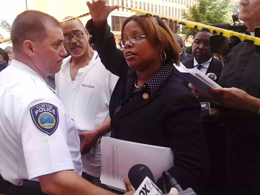 Police officer blocks State Representative Jamilah Nasheed from entering a government building Aug. 21, 2014. She was eventually given entrance after shouts and coalition. (Courtesy of The Final Call)