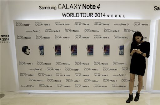 A model tries out a Samsung Electronics Co.'s latest Galaxy Note 4 smartphone as it is unveiled in Seoul, South Korea, Wednesday, Sept. 24, 2014. Samsung said Wednesday its latest Galaxy Note 4 smartphone will go on sale in China and South Korea later this week as its flagging mobile business tries to defend sales from Apple's new iPhones. Samsung said all three Chinese mobile carriers and all three South Korean mobile operators will begin Galaxy Note 4 sales on Friday. (AP Photo/Ahn Young-joon)