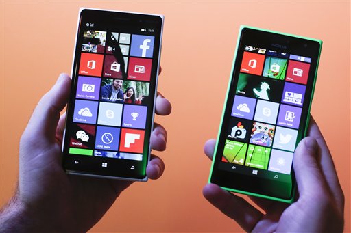 A man shows the new Lumia 830, left, and 730, right, smart phones during a Microsoft Nokia  presentation event at the consumer electronic fair IFA in Berlin, Thursday, Sept. 4, 2014. (AP Photo/Markus Schreiber)