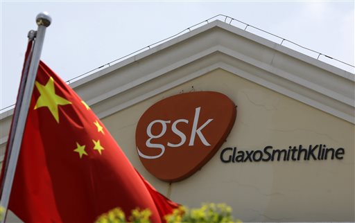 In this July 24, 2013 file photo, a Chinese flag is hoisted in front of a GlaxoSmithKline building in Shanghai, China. Drug maker GlaxoSmithKline was fined $492 million on Friday, Sept. 19, 2014 for bribing doctors in China in the biggest such penalty ever imposed by a Chinese court. The court sentenced the company's former China manager, Briton Mark Reilly, and four Chinese co-defendants to prison but postponed the sentences for two to four years, suggesting they may never be served. The court said it granted leniency because the defendants confessed. (AP Photo/Eugene Hoshiko, File)