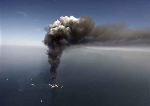 In this Wednesday, April 21, 2010 file photo, oil can be seen in the Gulf of Mexico, more than 50 miles southeast of Venice on Louisiana's tip, as a large plume of smoke rises from fires on BP's Deepwater Horizon offshore oil rig. An April 20, 2010 explosion at the offshore platform killed 11 men, and the subsequent leak released an estimated 172 million gallons of petroleum into the gulf. U.S. District Judge Carl Barbier ruled Thursday, Sept. 4, 2014, in New Orleans, La., that BP acted recklessly and bears most of the responsibility for the oil spill. The ruling exposes BP to about $18 million in civil fines under the Clean Water Act. (AP Photo/Gerald Herbert, File)