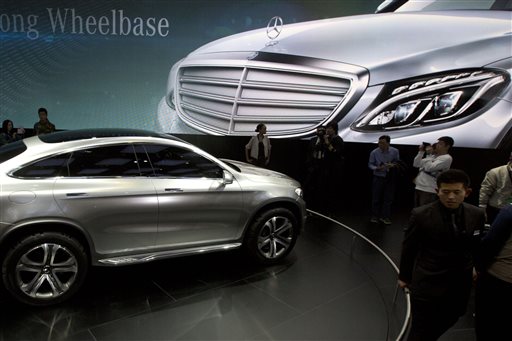 In this April 20, 2014 photo, visitors look at a Mercedes car at the company booth during the Auto China show in Beijing, China. Foreign companies in China feel increasingly targeted for unfair enforcement of anti-monopoly and other laws and might cut investment if conditions fail to improve, a business group said Tuesday, Sept. 2, 2014. (AP Photo/Ng Han Guan)