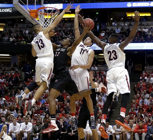 In this March 27, 2014, file photo, San Diego State forward Josh Davis (22) shoots between Arizona guard Nick Johnson (13), Aaron Gordon (11) and Rondae Hollis-Jefferson (23) during the first half in a regional semifinal of the NCAA men's college basketball tournament in Anaheim, Calif. This season, there are fewer star players, putting the focus on the team instead of individual players. (AP Photo/Jae C. Hong, File)