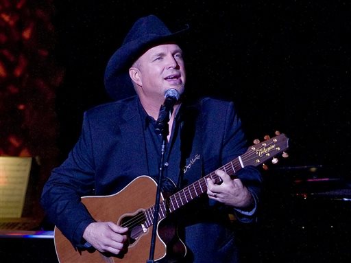 In this Nov. 17, 2014 file photo, Garth Brooks performs the 2014 ASCAP Centennial Awards, benefiting the ASCAP Foundation and its music education, talent development and humanitarian activities, at the Waldorf-Astoria in New York. Brooks has canceled a Thanksgiving appearance on NBC's "Tonight" show because he said it "seemed distasteful" given the reaction to the decision not to prosecute Ferguson police officer Darren Wilson for the shooting of Michael Brown this summer. NBC on Wednesday, Nov. 26, confirmed the postponement, saying Brooks was being replaced on the show by Whoopi Goldberg and Tom Colicchio. (Photo by Stephen Chernin/Invision/AP, File)