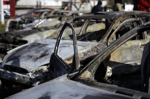 A row of burned cars sit on the lot of a used car dealer Tuesday, Nov. 25, 2014, in Dellwood, Mo. The cars are one example of property damage caused by rioters after a grand jury decided not to indict a Ferguson police officer in the shooting death of Michael Brown. (AP Photo/Jeff Roberson)