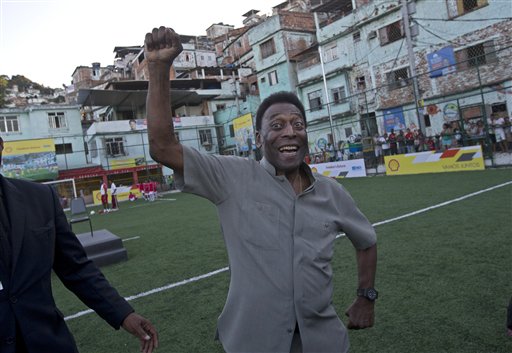 In this Sept. 10, 2014 file photo, Brazilian soccer great Pele pumps his fist in the air while he poses for photos during the inauguration of a soccer pitch to be powered by players' footsteps, at the Morro da Mineira favela, in Rio de Janeiro, Brazil. Pele remains in good condition after undergoing surgery to remove kidney stones, the Albert Einstein Hospital in Sao Paulo said in a statement released Friday, Nov. 14, 2014. (AP Photo/Silvia Izquierdo, File)
