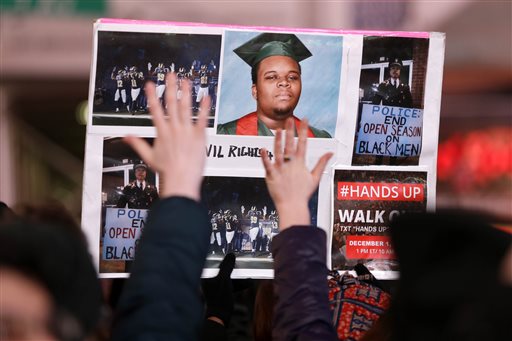 People participate in a protest in response to the grand jury's decision in the Eric Garner case in Times Square in New York, Wednesday, Dec. 3, 2014. The grand jury cleared the white New York City police officer Wednesday in the videotaped chokehold death of Garner, an unarmed black man, who had been stopped on suspicion of selling loose, untaxed cigarettes, a lawyer for the victim's family said. (AP Photo/Seth Wenig)