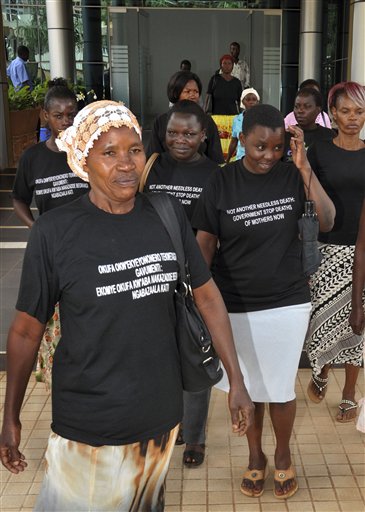 In this photo taken Tuesday, June 5, 2012, Ugandan women walk out of the Constitutional Court disappointed after losing a case against the government over maternal deaths during childbirth, prior to taking the issue further to the Supreme Court, in the capital Kampala, Uganda. More than 100 women die during childbirth each week in Uganda, a heartbreaking statistic that has energized activists to go to the Supreme Court in a bid to force the government to put more resources toward maternal health care to prevent the wave of deaths. Writing on t-shirts in English and Swahili reads "Not another needless death: Government stop deaths of mothers now". (AP Photo/Stephen Wandera)