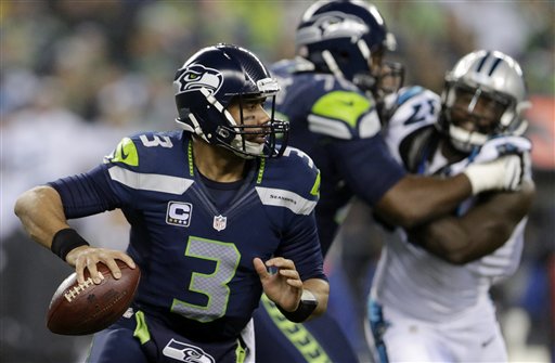 Seattle Seahawks quarterback Russell Wilson (3) scrambles against the Carolina Panthers during the first half of an NFL divisional playoff football game in Seattle, Saturday, Jan. 10, 2015. (AP Photo/John Froschauer)
