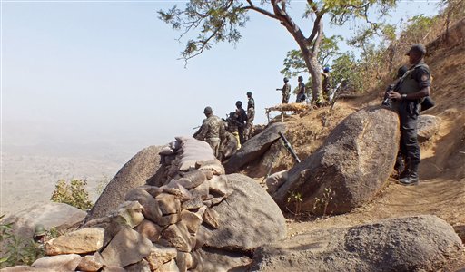 In this photo taken on Thursday, Feb. 19, 2015, Cameroon soldiers stand guard at a lookout post as they take part in operations against the Islamic extremist group Boko Haram near the village of Mabass, Cameroon. Cameroon officials say prisons are overcrowded with suspected Islamic extremists whose insurgency has spilled from Nigeria. (AP Photo/Edwin Kindzeka Moki)