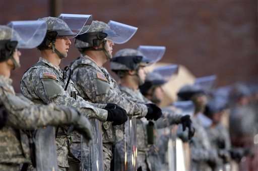 In this Nov. 25, 2014 file photo, National Guard troops stand in front of the Ferguson, Mo., Police Department a day after a grand jury's decision in the fatal shooting of Michael Brown. Newly released documents reveal that police planning for a grand jury announcement wanted Guard troops and armored Humvees stationed in the Ferguson neighborhood where Brown had been shot. But the records show the requests were not granted, because Missouri Gov. Jay Nixon preferred to use the Guard in a support role to police. (AP Photo/Charlie Riedel, File)