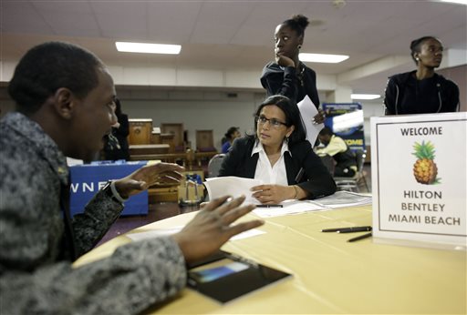 In this Friday, Jan. 23, 2015 photo, Debbie Ramsawak, Director of Operations at the Hilton Bentley Miami Beach hotel, center, seated, talks with job applicant Zikey Cook, 24, left, during a job fair at the Hospitality Institute, in Miami. The job market remains a frustrating place for Americas 8 million unemployed even at a time when employers are adding jobs and hanging out the most help-wanted signs in 14 years. (AP Photo/Lynne Sladky)