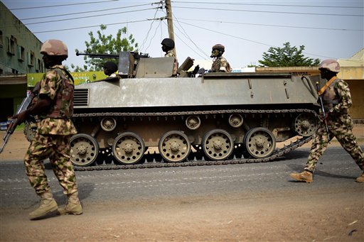 In this photo taken Monday March 9, 2015, Nigerian troops patrol in the north-eastern Nigeria city of Mubi, some 20 kms (14 miles) west of the Cameroon border. Nigerian troops recaptured Mubi from Boko Haram militants in February 2015. On Friday March 13, 2015, the Islamic State group's media arm Al-Furqan, in an audio recording by spokesman Abu Mohammed al-Adnani, said that Boko Haram's pledge of allegiance has been accepted, claiming the caliphate has now expanded to West Africa. (AP Photo/str)