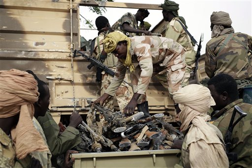 In this file photo taken on Wednesday March 18, 2015, Chadian soldiers collect weapons seized from Boko Haram fighters  in the Nigerian city of Damasak, Nigeria.  Hundreds of civilians, including many children, have been kidnapped and are being used as human shields by Boko Haram extremists, a top Nigerian official confirmed Wednesday, March 25, 2015. (AP Photo/Jerome Delay, File)