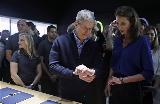 Apple CEO Tim Cook, left, and Christy Turlington Burns, founder of Every Mother Counts, look at the new Apple Watch in the demo room after an Apple event on Monday, March 9, 2015, in San Francisco. (AP Photo/Eric Risberg)