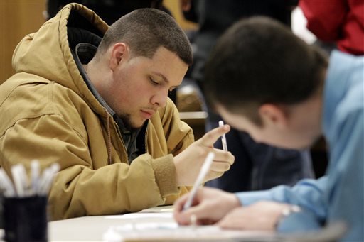 In this Jan. 29, 2015 file photo, Tyler Kelly, 19,  left, fills out applications for parking enforcement and environmental compliance jobs during a public safety job fair at City Hall in Saginaw, Mich. The  Labor Department releases job openings and labor turnover survey for January on Tuesday, March 10, 2015.  (AP Photo/The Saginaw News, David C. Bristow)