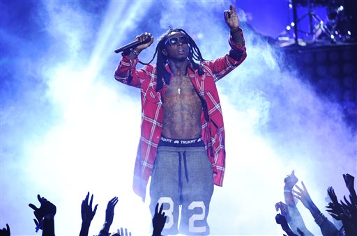 In this June 29, 2014 file photo, Lil' Wayne performs at the BET Awards at the Nokia Theatre in Los Angeles. Police have responded to a report of 4 people shot at the Miami Beach home of rapper Lil Wayne. Miami Beach Det. Vivian Thayer says police units responded Wednesday, March 11, 2015, after someone called to say four people had been shot at the waterfront home. (Photo by Chris Pizzello/Invision/AP, File)