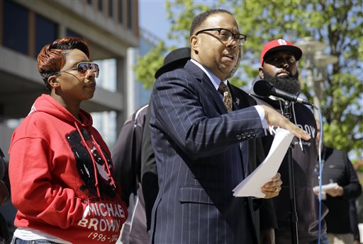 Lesley McSpadden, left, and Michael Brown Sr., right, the parents of Michael Brown, listen as their attorney Anthony D. Gray speaks during a news conference Thursday, April 23, 2015, in Clayton, Mo. The parents of Michael Brown filed a wrongful-death lawsuit Thursday against the city of Ferguson, Mo., over the fatal shooting of their son by a white police officer, a confrontation that sparked a protest movement across the United States. (AP Photo/Jeff Roberson)