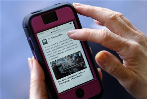 In this Tuesday, April 28, 2015 photo, an unidentified person uses a mobile phone to read the news from The Huffington Post on Facebook, in Los Angeles. State of the News Media 2015, published Wednesday, April 29, 2015, by the Pew Research Centers Journalism Project found that nearly half of Web users learn about politics and government from Facebook, roughly the same percentage as those who seek the news through local television and double those who visit Yahoo or Google News. (AP Photo/Richard Vogel)