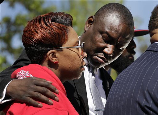 Family attorney Benjamin L. Crump, right, puts his arm around Lesley McSpadden, the mother of Michael Brown, during a news conference Thursday, April 23, 2015, in Clayton, Mo. The parents of Michael Brown filed a wrongful-death lawsuit Thursday against the city of Ferguson, Mo., over the fatal shooting of their son by a white police officer, a confrontation that sparked a protest movement across the United States. (AP Photo/Jeff Roberson)