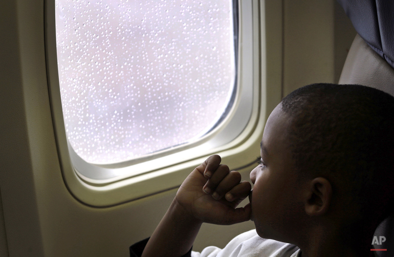 Xavier Perry, 5, looks out of an airplane window at Baltimore-Washington International Thurgood Marshall Airport, Saturday, Dec. 6, 2014, in Linthicum, Md., during Wings for Autism, an airport rehearsal for children with autism spectrum disorders, their families and aviation officials. Families took part in a typical airport experience, from check-in and security to boarding a plane, with the intention of alleviating some of the stress of air travel for children with autism. (AP Photo/Patrick Semansky)