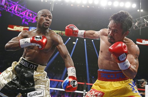 Manny Pacquiao, from the Philippines, right, throws a right against Floyd Mayweather Jr., during their welterweight title fight on Saturday, May 2, 2015 in Las Vegas. (AP Photo/John Locher)