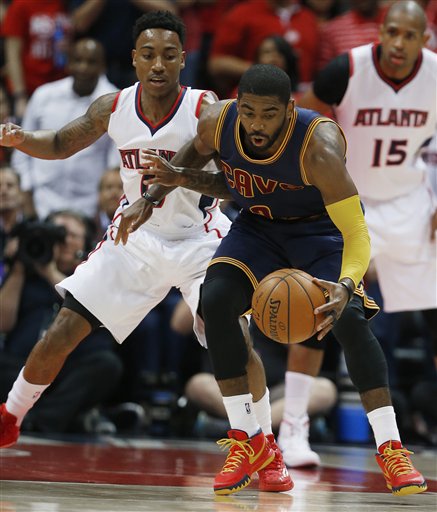 Cleveland Cavaliers guard Kyrie Irving (2) moves the ball as Atlanta Hawks guard Jeff Teague (0) looks on during the first half in Game 1 of the Eastern Conference finals of the NBA basketball playoffs, Wednesday, May 20, 2015, in Atlanta. (AP Photo/John Bazemore)