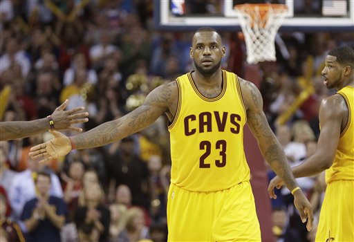 Cleveland Cavaliers forward LeBron James slaps hands with a teammate after scoring against the Chicago Bulls during the second half of Game 5 in a second-round NBA basketball playoff series Tuesday, May 12, 2015, in Cleveland. The Cavaliers won 106-101. (AP Photo/Tony Dejak)