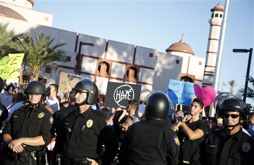 Protesters gather outside the Islamic Community Center of Phoenix, Friday, May 29, 2015. About 500 protesters gathered outside the Phoenix mosque on Friday as police kept two groups sparring about Islam far apart from each other.  (AP Photo/Rick Scuteri)