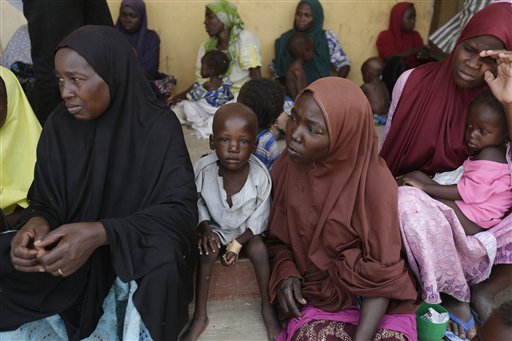Women and children rescued by Nigerian soldiers from Boko Haram extremists at Sambisa Forest wait for treatment at at a refugee camp in Yola, Nigeria Monday, May 4, 2015. Even with the crackle of gunfire signaling rescuers were near, the horrors did not end: Boko Haram fighters stoned captives to death, some girls and women were crushed by an armored car and three died when a land mine exploded as they walked to freedom. (AP Photo/Sunday Alamba)