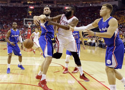Houston Rockets' James Harden, center, is pressured by Los Angeles Clippers' Spencer Hawes (10) and Blake Griffin, right, during the first half in Game 5 of the NBA basketball Western Conference semifinals Tuesday, May 12, 2015, in Houston. (AP Photo/David J. Phillip)