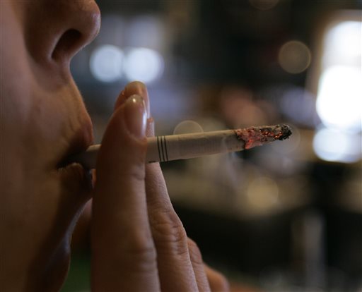 In this Tuesday, June 3, 2008 file photo, an employee smokes a cigarette at a bar and restaurant in Harrisburg, Pa. In a study released Wednesday, May 13, 2015, smokers with $150 of their own money at stake were far more likely to quit than smokers who didnt have to wager their money to get cash rewards. "A bit of a stick was much better than pure carrot," said the study's lead author, Dr. Scott Halpern of the University of Pennsylvania. But heres the catch: Few people were willing to bet on themselves. Nearly everyone who was offered the rewards-only option, though, signed up for a stop smoking program. (AP Photo/Carolyn Kaster)