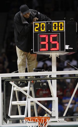 In this March 19, 2010, file photo, a technician adjusts a shot clock after it malfunctioned and delayed the start of the California against Louisville NCAA first-round college basketball game in Jacksonville, Fla. On Monday, June 8, 2015, the NCAAs Playing Rules Oversight Panel officially approved that mens college basketball teams will play with a quicker shot clock (30 seconds instead of 35 seconds) and fewer timeouts next season which were made last month by the basketball rules committee. Teams will have one fewer second-half timeout, and if either team calls a timeout within 30 seconds of a media timeout, it would count as the scheduled break. (AP Photo/Steve Helber, File)