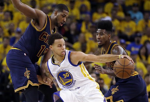 Golden State Warriors guard Stephen Curry (30) tries to control the ball as he is guarded by Cleveland Cavaliers center Tristan Thompson (13) and guard Iman Shumpert during the first half of Game 2 of basketball's NBA Finals in Oakland, Calif., Sunday, June 7, 2015. (AP Photo/Ben Margot)
