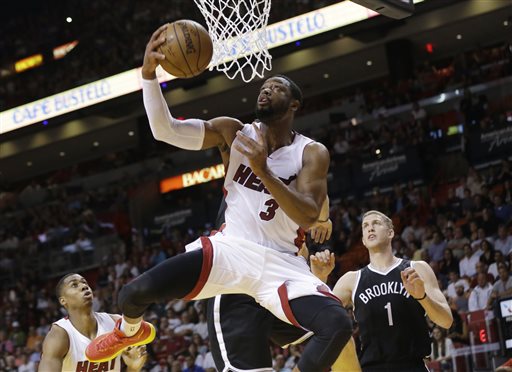 In this Jan. 4, 2015, file photo, Miami Heat guard Dwyane Wade (3) shoots in front of Brooklyn Nets center Mason Plumlee (1) during the first half of an NBA basketball game in Miami. Wade announced Monday, June 29, 2015, that he will elect to become a free agent. (AP Photo/Lynne Sladky, File)