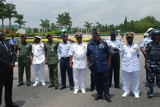 In this Monday, May. 26, 2014 file photo, Nigeria's chief of defense staff Air Marshal Alex S. Badeh, foreground third right, and other military chiefs wait to address the Nigerians Against Terrorism group during a demonstration calling on the government to rescue the kidnapped girls of the government secondary school Chibok, in Abuja, Nigeria. Nigerian military abuses caused the deaths of some 8,000 people in the fight against Boko Haram extremists, Amnesty International said Wednesday, June. 3, 2015  in a report naming senior officers it wants investigated for alleged war crimes. (AP Photo/Olamikan Gbemiga File)