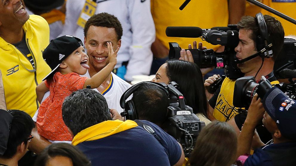 Golden State Warriors guard Stephen Curry holds his daughter Riley after Game 5 of the NBA basketball Western Conference finals against the Houston Rockets in Oakland, Calif., May 27, 2015. (Tony Avelar/AP)