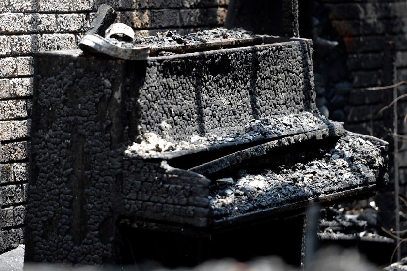 A destroyed piano is part of the charred remains of Briar Creek Road Baptist Church Wednesday, June 24, 2015 in Charlotte, N.C.  Investigators with the Charlotte Fire Department say a fire at the predominantly black church is a case of arson. The church's congregation is predominantly black, and there are about 100 members. Investigators are not sure if the fire was racially motivated.  (Davie Hinshaw/The Charlotte Observer via AP)