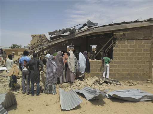 People gather at the site of suicide bomb attack at Redeem Christian church in Potiskum, Nigeria, Sunday, July 5, 2015.  Witnesses say a woman suicide bomber blew up in the midst of a crowded evangelical Christian church service on Sunday and killed at least five people, the latest in a string of bombings and shooting attacks blamed on the Islamic extremist group Boko Haram that has killed some 200 people in the past week. (AP Photo/Adamu Adamu)