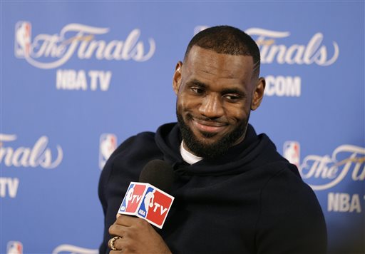 In this June 7, 2015, file photo, Cleveland Cavaliers forward LeBron James smiles during a news conference after Game 2 of basketball's NBA Finals in Oakland, Calif. Two people familiar with the negotiations say LeBron James has agreed to a one-year, $23 million contract with the Cavaliers for next season. The deal includes a player option for 2016-17. The people spoke to The Associated Press on condition of anonymity Thursday because the contract has not been signed. James has informed the team he will return. (AP Photo/Ben Margot, File)